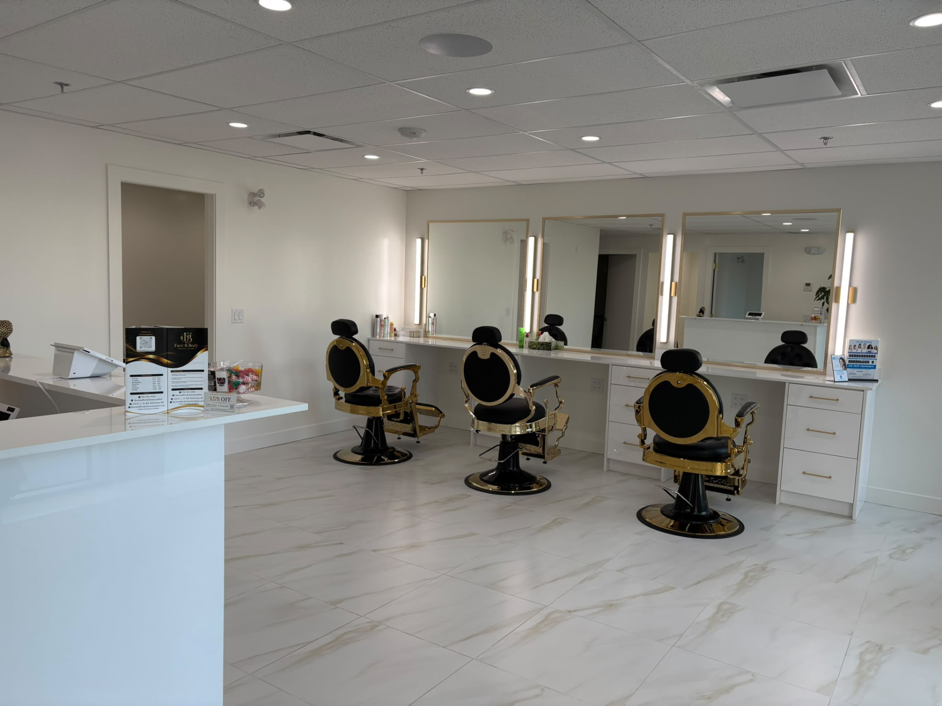 Face & Body Beauty Salon interior with three black and gold styling chairs