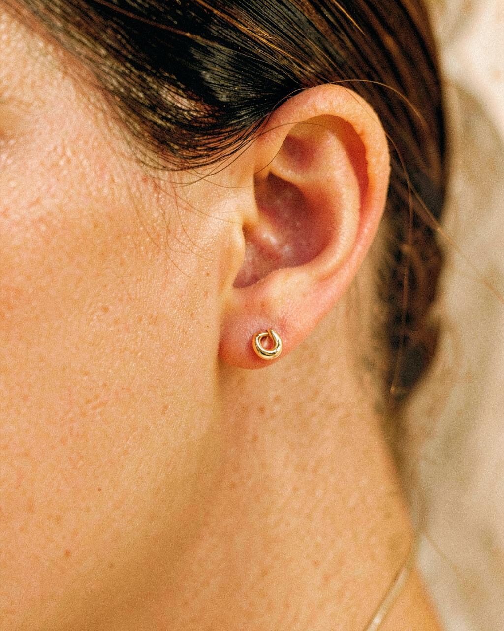 A small gold hoop in a fresh ear piercing
